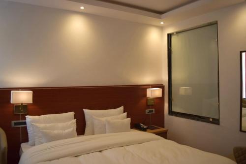a bedroom with a large bed and a large mirror at Hotel The Haven - Centrally Heated and Air Conditioned in Kargil