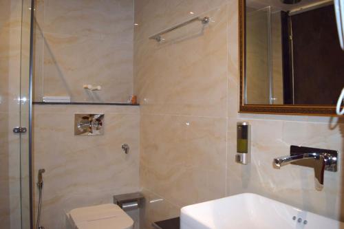 a bathroom with a shower and a sink and a toilet at Hotel The Haven - Centrally Heated and Air Conditioned in Kargil