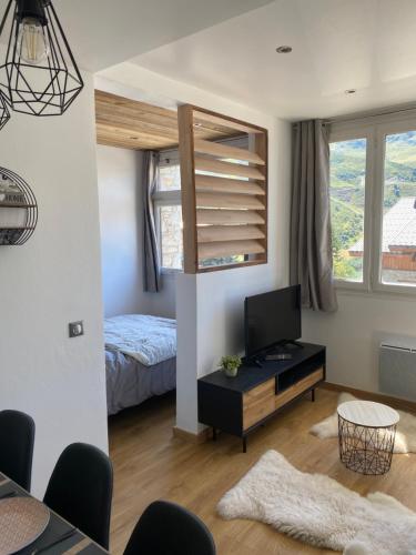 un salon avec un lit et une télévision dans l'établissement Escapade scandinave aux Menuires, aux Menuires