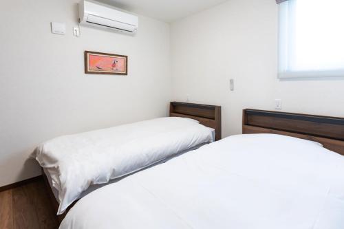 a bedroom with two beds and a window at Villa Fuji-nishiki in Fujikawaguchiko