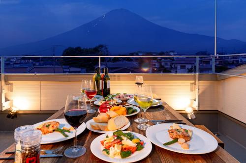 a table with plates of food and glasses of wine at Villa Fuji-nishiki in Fujikawaguchiko