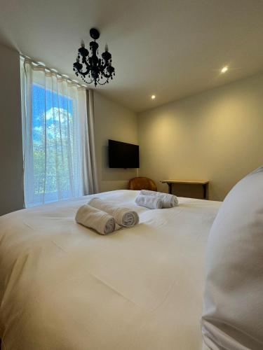 a bedroom with a large white bed with towels on it at Appartements confortables avec vue montagne Alpes Française - Queyras - Villa Belle Fleur in Château-Ville-Vieille