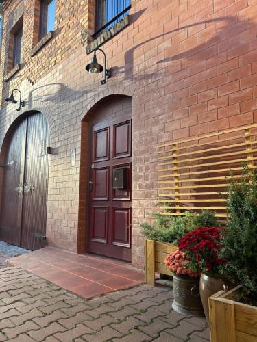 a brick building with a brown door and some plants at Stara Kamienica in Szczytno
