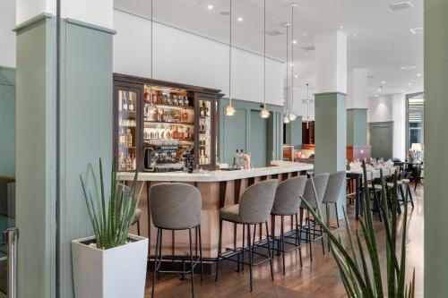 a bar in a restaurant with stools at Waldstätterhof Swiss Quality Hotel in Luzern