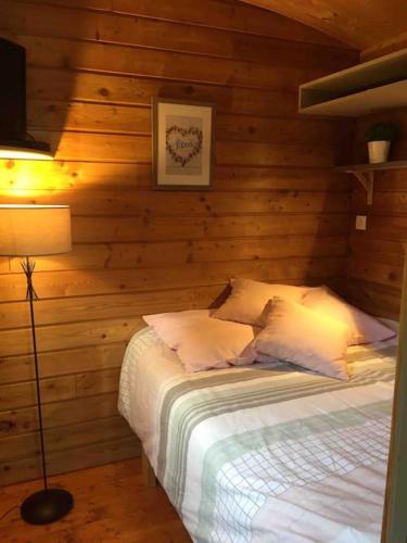 une chambre avec un lit dans un mur en bois dans l'établissement Jolie Roulotte tout confort, à Saint-Amand-les-Eaux