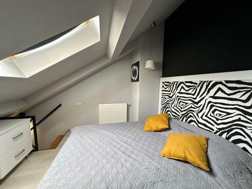 ein Schlafzimmer mit einem Bett mit zwei gelben Kissen in der Unterkunft Two Level Apartment near Gondola in Gudauri