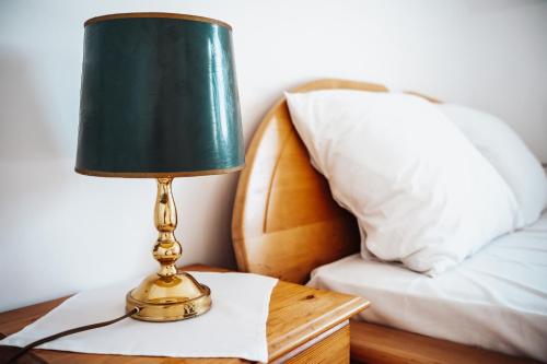 a lamp sitting on a table next to a bed at Zajazd Hetmański-Noclegi-Nowy Wiśnicz in Nowy Wiśnicz
