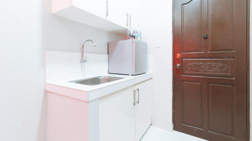 a kitchen with a sink and a red door at RedDoorz near NAIA Terminal 1 in Manila