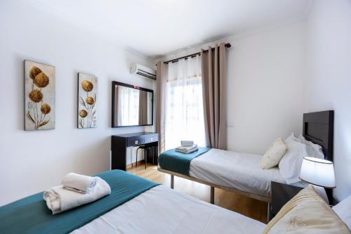 a room with two beds and a window at Portugal Home in Lagos