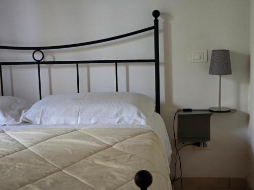 a bedroom with a bed and a lamp on a table at Villetta Pia in Contignano