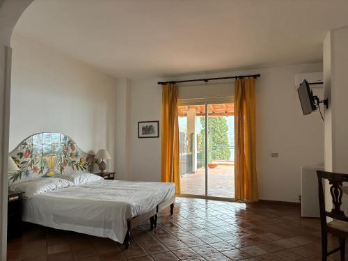 a bedroom with a bed and a sliding glass door at Bay Palace Mazzarò in Taormina