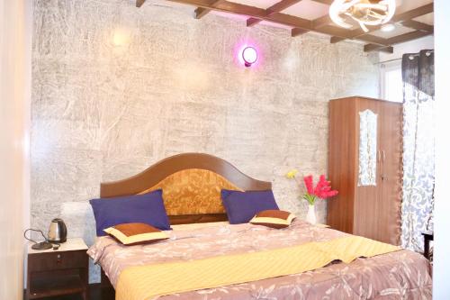 1 dormitorio con 1 cama con sábanas azules y amarillas en Cloudy Vista Kodai, en Kodaikanal