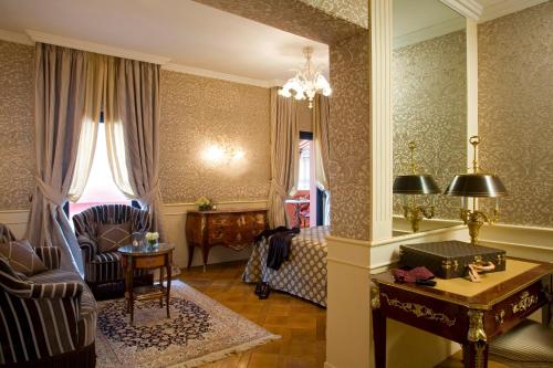 a living room with a chair and a table at Grand Hotel Majestic gia' Baglioni in Bologna