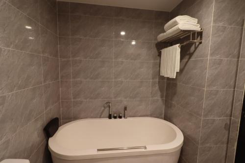 a bathroom with a toilet and a white tub at Mahasakor Inn in Phnom Penh