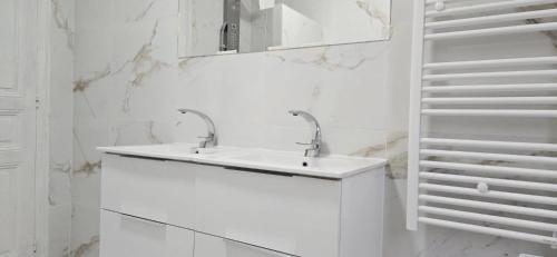 une salle de bain blanche avec un lavabo et un miroir dans l'établissement Studio d athis, à Athis-Mons