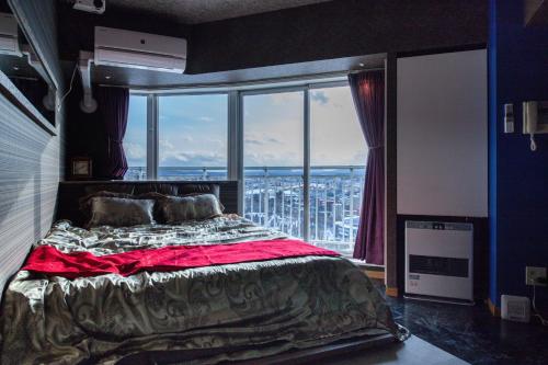 a bedroom with a bed and a large window at Meteor Shower in Sapporo