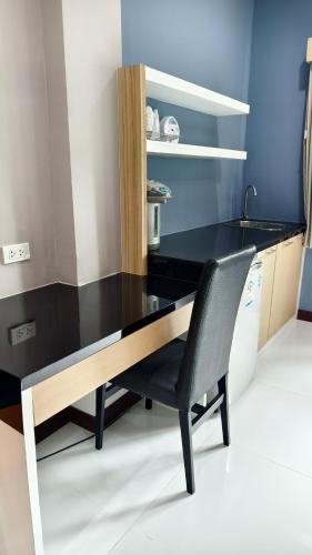 a black desk with a chair in a kitchen at Eastpana Executive Residence 304 Prachinburi in Si Maha Phot