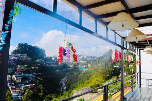 Una vista desde un balcón con vista a una montaña. en Cloudy Vista Kodai, en Kodaikanal