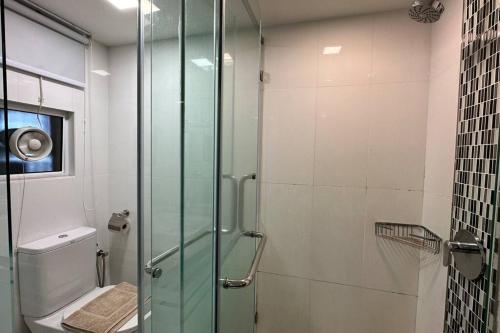 a bathroom with a glass shower with a toilet at Seaview Seafront Duplex in Town with WiFi & Full Kitchen 83A in Georgetown
