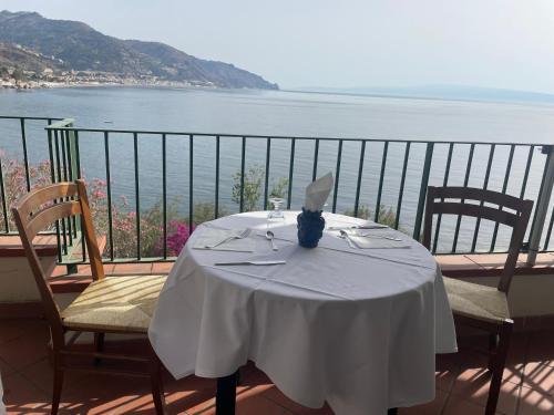 a table on a balcony with a view of the water at Bay Palace Mazzarò in Taormina