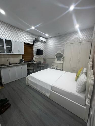 a bedroom with a large white bed and a kitchen at Khách sạn Hướng Dương in Hanoi
