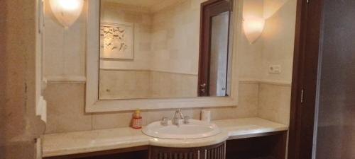 un baño con lavabo y espejo en Villa Gadja Bali, en Jimbaran