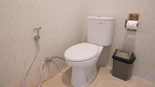a bathroom with a white toilet with a hose at Summer of Surf Canggu in Canggu