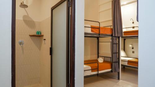 a room with bunk beds and a shower at Summer of Surf Canggu in Canggu