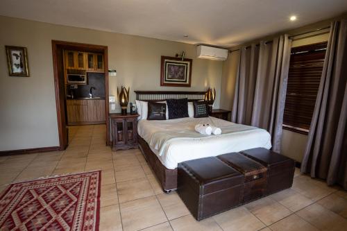 a bedroom with a bed and a table and a couch at Waterfalls Boutique Hotel in Pretoria