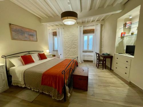 a bedroom with a bed and a desk and a television at La Casa della Campana in Cortona