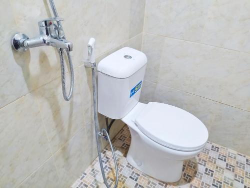 a bathroom with a toilet and a shower at Zumo Home Tegal Mitra RedDoorz in Tegal