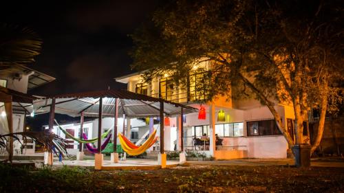 a group of hammocks in front of a building at night at Hostería "El Paraíso" in Montañita