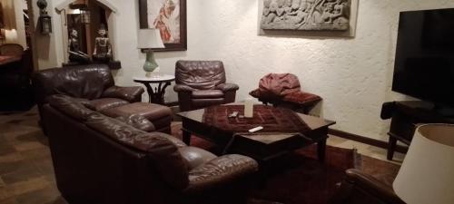 sala de estar con muebles de cuero y mesa en Villa Gadja Bali, en Jimbaran