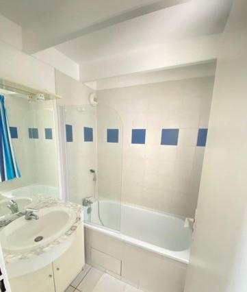 une salle de bain blanche avec un lavabo et une baignoire dans l'établissement ALIENOR VUE MER 2 à 4 PERSONNES, à Fouras