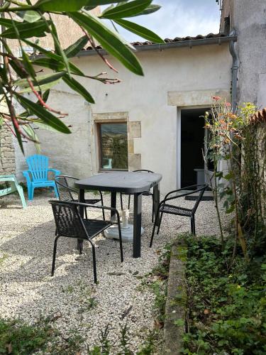 une table et des chaises devant une maison dans l'établissement Maison de la Greve - coeur de Marans avec cour, à Marans