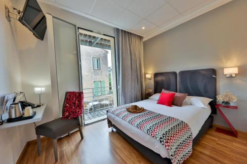 a bedroom with a large bed and a window at Hôtel Méditerranée in Calvi
