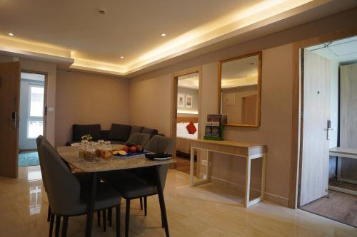 a dining room with a table and chairs and a living room at Sarovar Portico Kolkata in Kolkata