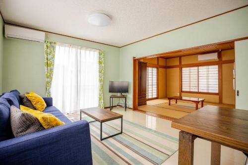 a living room with a blue couch and a table at Twilight Villa Onjuku - Vacation STAY 52776v in Iwada