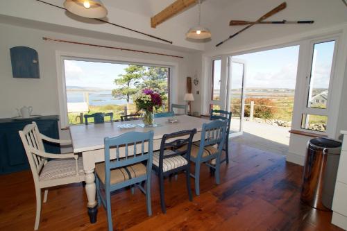comedor con mesa y sillas con vistas en The Sea House, en Dungloe