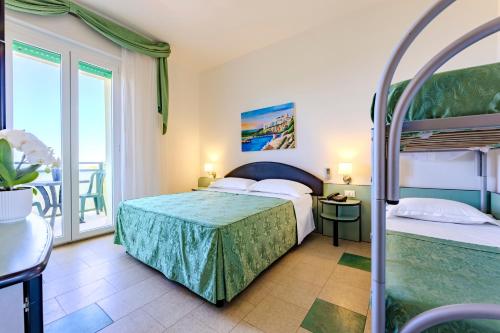 a bedroom with two bunk beds and a balcony at Paglianza Hotel in Peschici