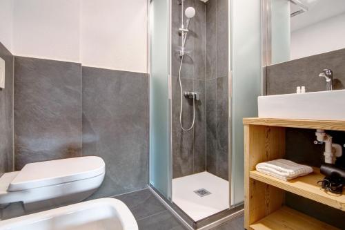a bathroom with a shower and a toilet and a sink at Agriturismo Montespluga in Madesimo