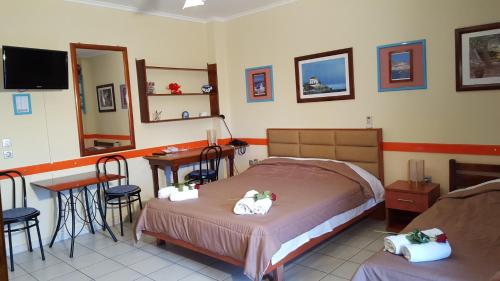 a bedroom with a bed and a table and a mirror at Stella Family Apartments in Síndos