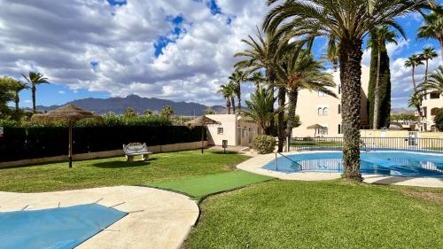 einen Garten mit Pool und Palmen in der Unterkunft Playa mar by Gloove in San Juan de los Terreros