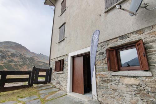 a building with a window and a sign next to it at Agriturismo Montespluga in Madesimo