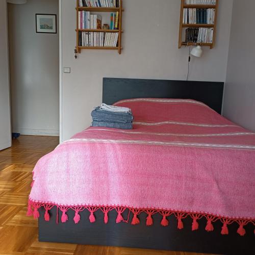 - un lit avec une couverture rose dans l'établissement Chambre chez Casa Créteil, à Créteil