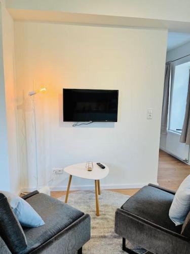 a living room with a couch and a tv on a wall at Kranichrast in Tarmow