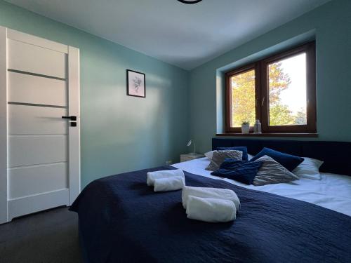 a bedroom with a large bed with two towels on it at Apartamenty River in Wisła