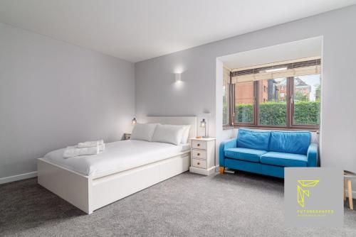 a bedroom with a bed and a blue couch at GuestReady - Cosy Wimbledon Studio Flat in London