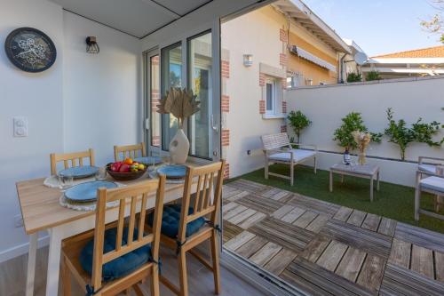d'une terrasse avec une table et des chaises en bois sur un balcon. dans l'établissement La Truffière - Charmante maison avec terrasse, à Arcachon