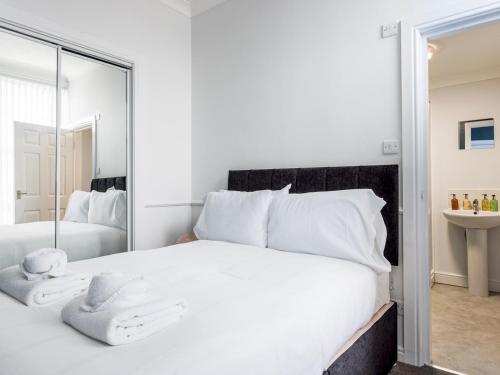 a bedroom with a large white bed with a mirror at Abdiel 6 · Stylish 1st-Floor Retreat by Hartlepool Marina Pass the Keys in Hartlepool
